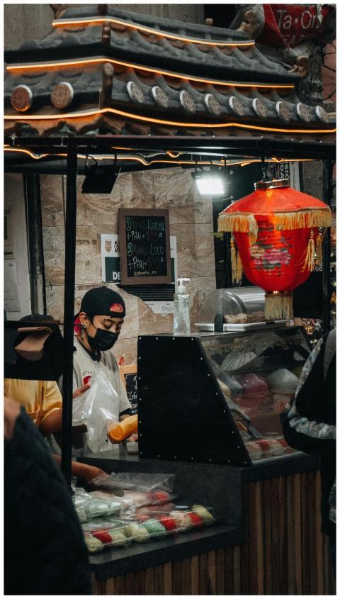 Asian street vendor preparing food at an outdoor m