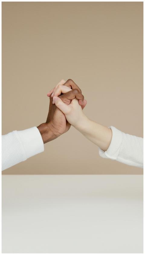 Close-up of two diverse hands gripping in a gestur