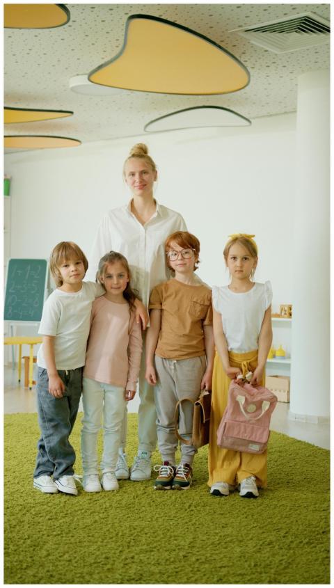 A cheerful teacher with a group of children in a b