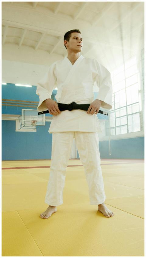 Martial artist in a white gi stands confidently in