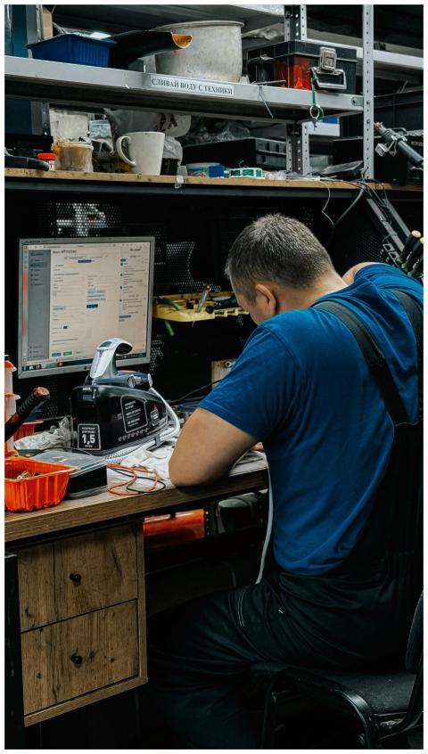 Technician focused on computer repair in cluttered