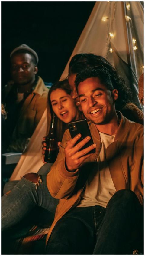 A group of friends socializing around a tent at ni