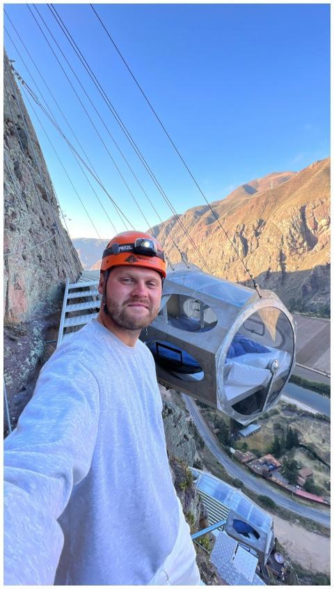 Man enjoying a thrilling stay in a cliffside pod o