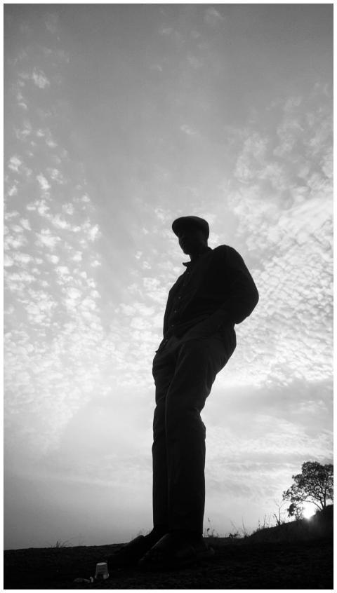 A striking silhouette of a man against a cloudy sk