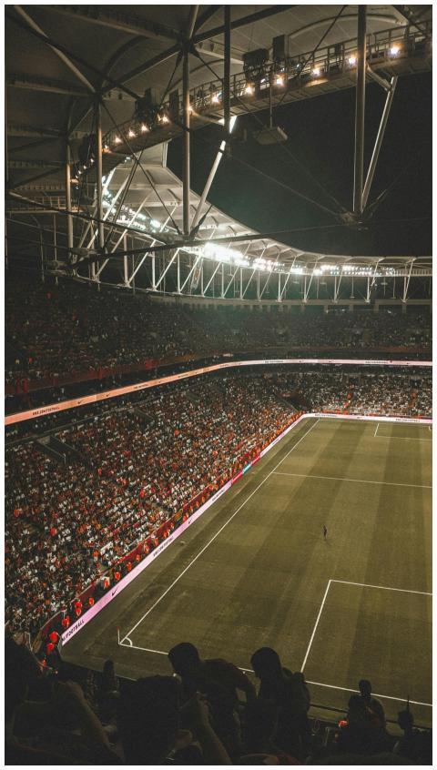 A vibrant night soccer match with a full audience