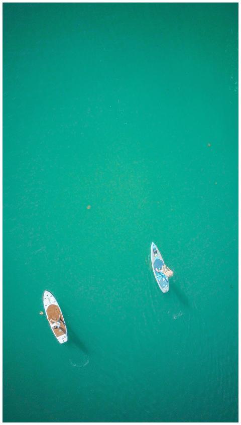Drone shot capturing two people paddleboarding on