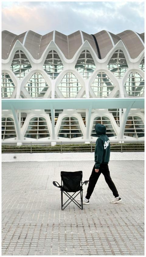 A person walks past a modern architectural buildin