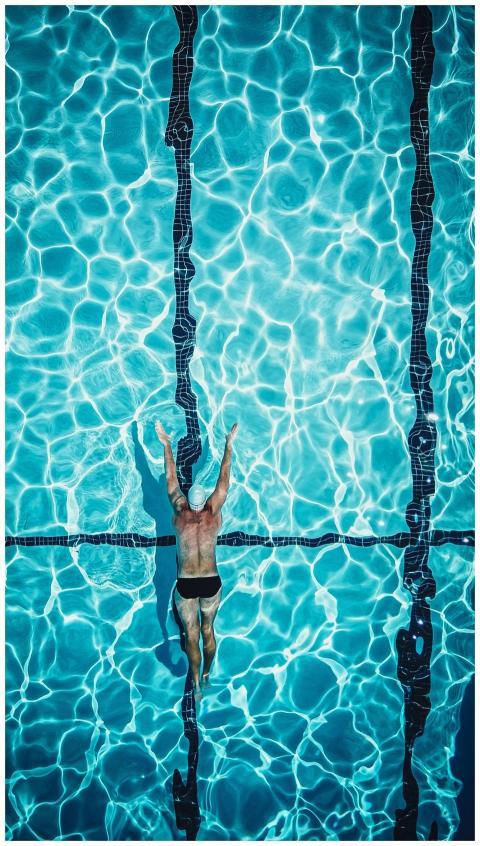 Dynamic aerial view of a swimmer in a brightly lit