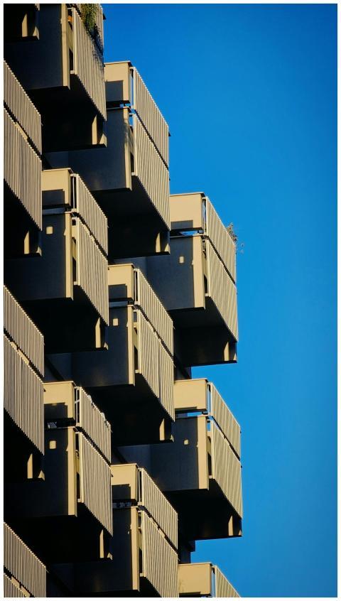 Detailed view of geometric balconies against a blu