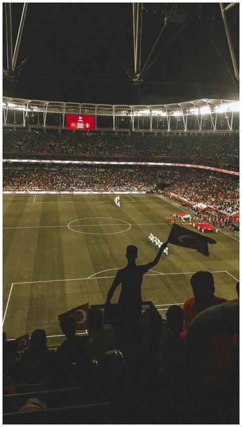 Exciting night soccer game with fans cheering in a