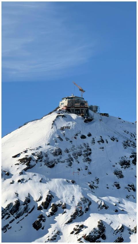 Majestic snowy peak with a structure atop in Laute