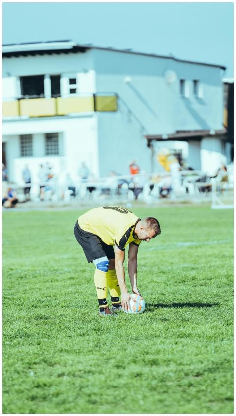 Focused soccer player in yellow jersey prepares fo