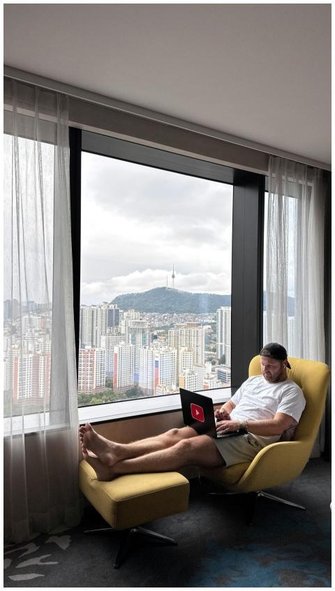 Man working on a laptop in a hotel room with a vie