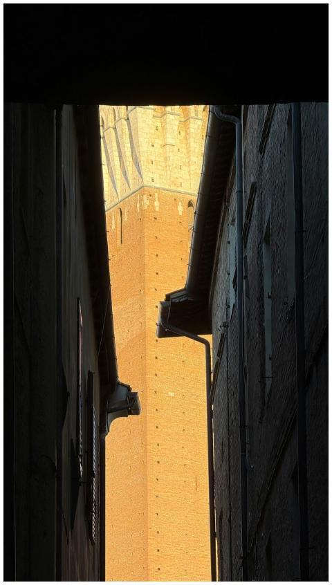 View of a medieval tower framed by narrow alleyway