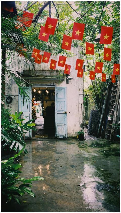 Vietnamese courtyard with red flags and lush green