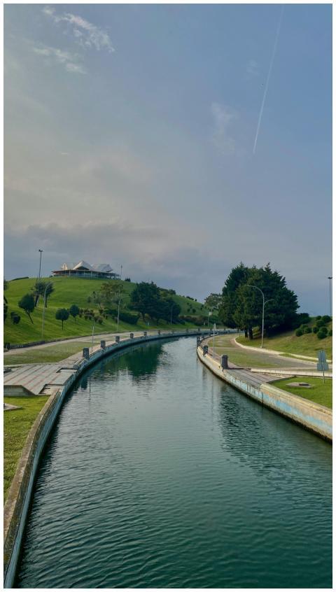 Peaceful canal winding through a green park settin