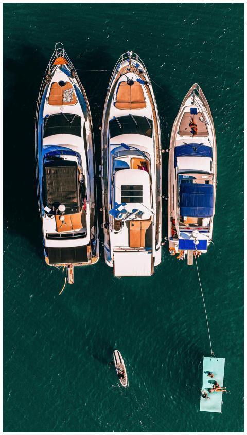 Aerial shot of three luxury yachts moored side by