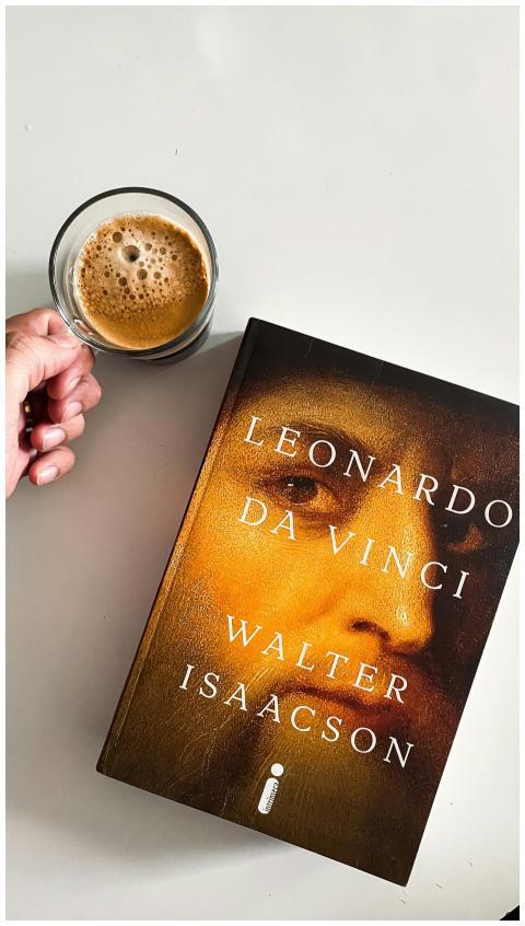 A person enjoys coffee while holding a Leonardo da