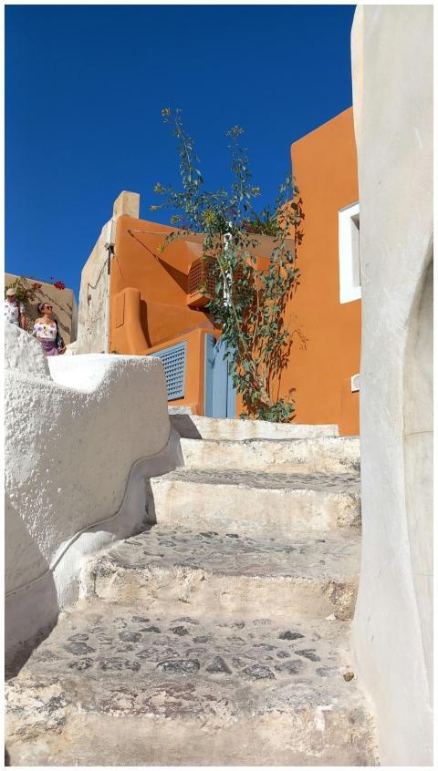 A sunny Greek alley with vibrant orange architectu