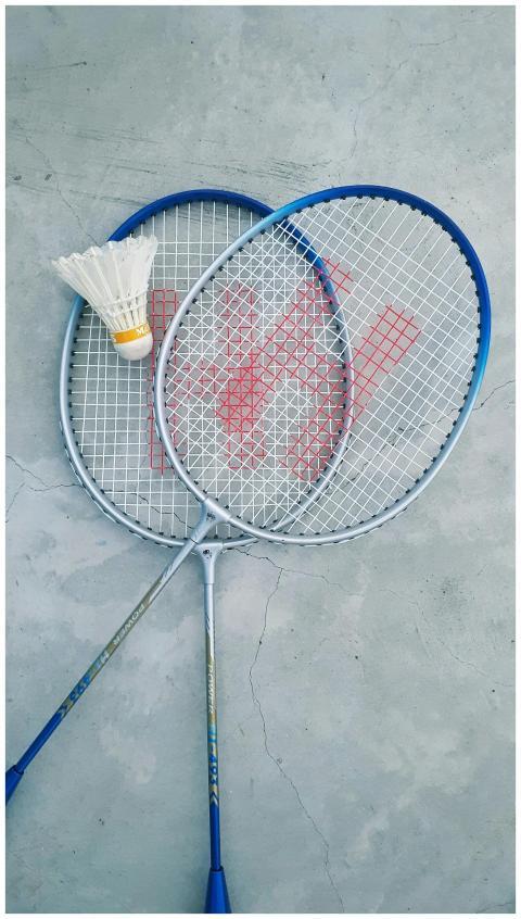Top view of two badminton rackets and a shuttlecoc