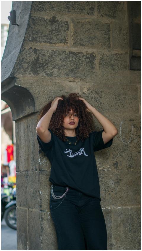 Stylish woman poses against a stone wall in a bust