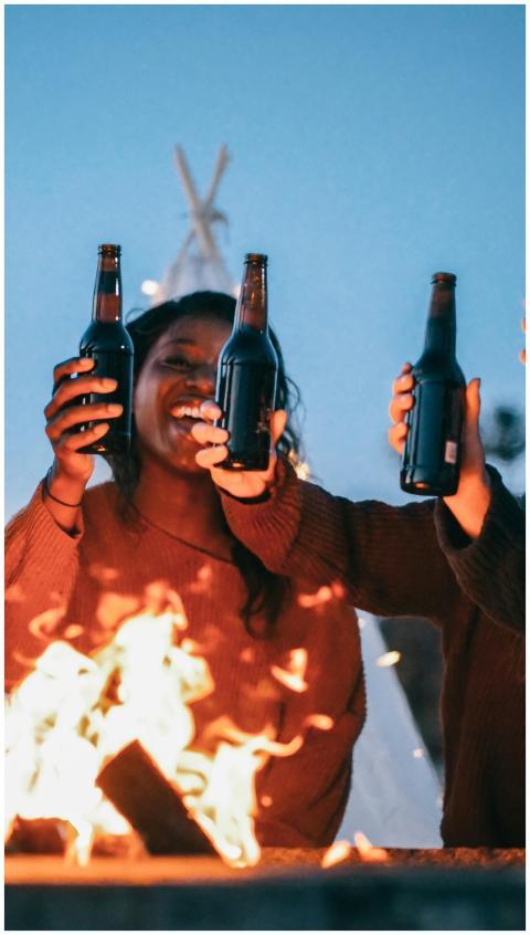 Group of friends celebrating with drinks around a