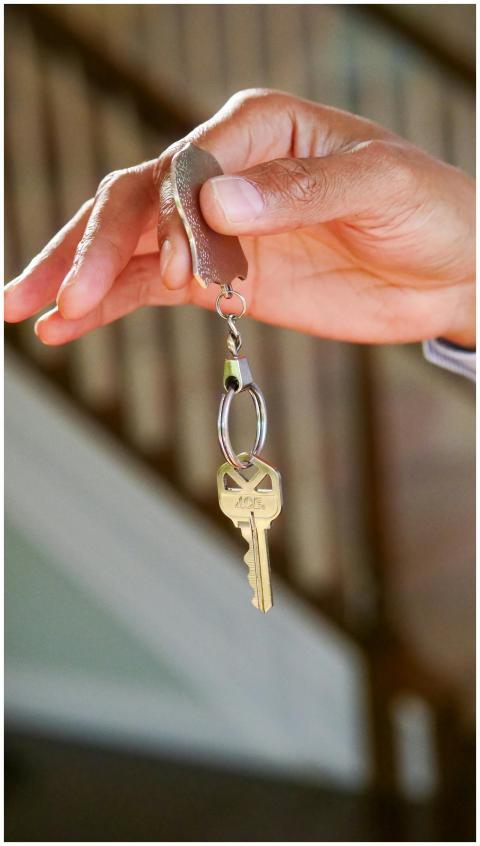 Close-up of a hand holding a key, symbolizing new