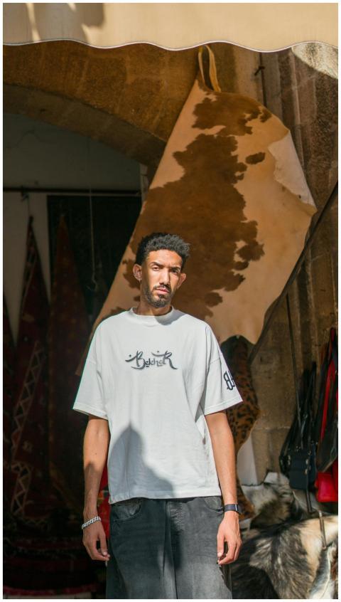 A man standing casually in a Moroccan archway surr