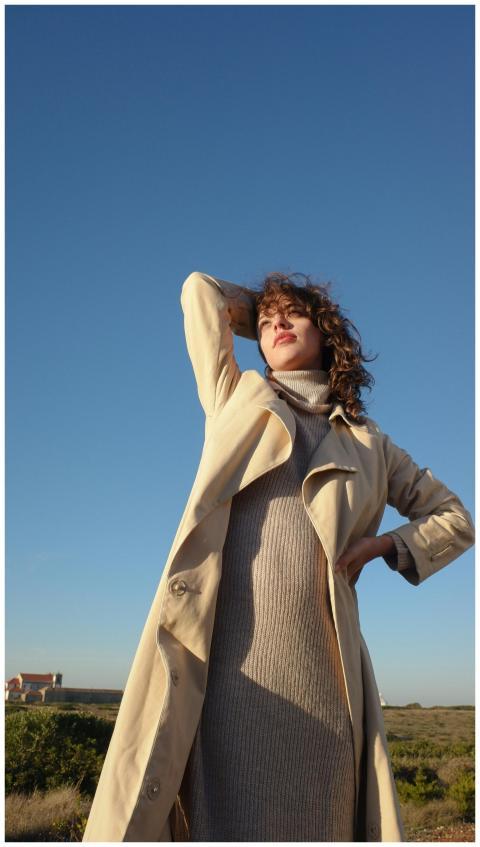 A fashionable woman poses confidently outdoors in