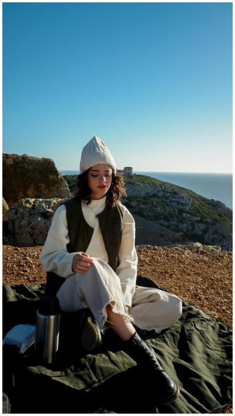 A woman in a beanie enjoying the view by the rocky