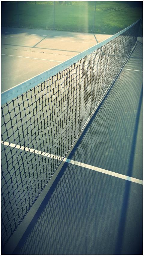 A serene view of an empty tennis court in Menands,
