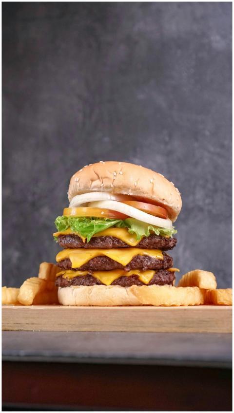 Delicious triple cheeseburger with sesame bun, let