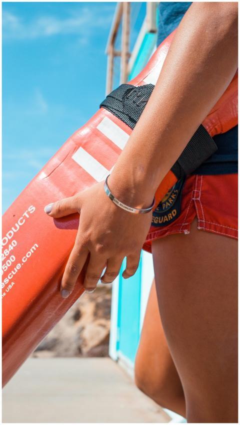 Lifeguard holding a rescue tube on a sunny Malibu