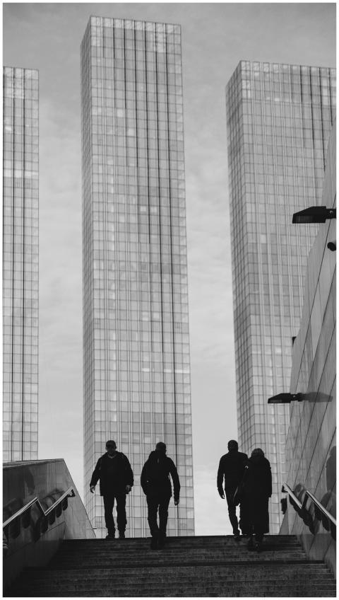 Silhouetted pedestrians in an urban landscape by s