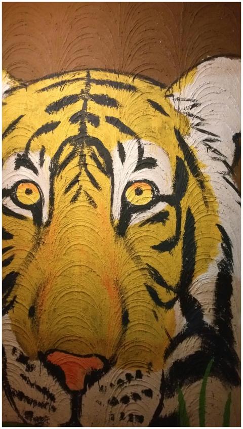 Close-up view of a vibrant tiger painting on a tex