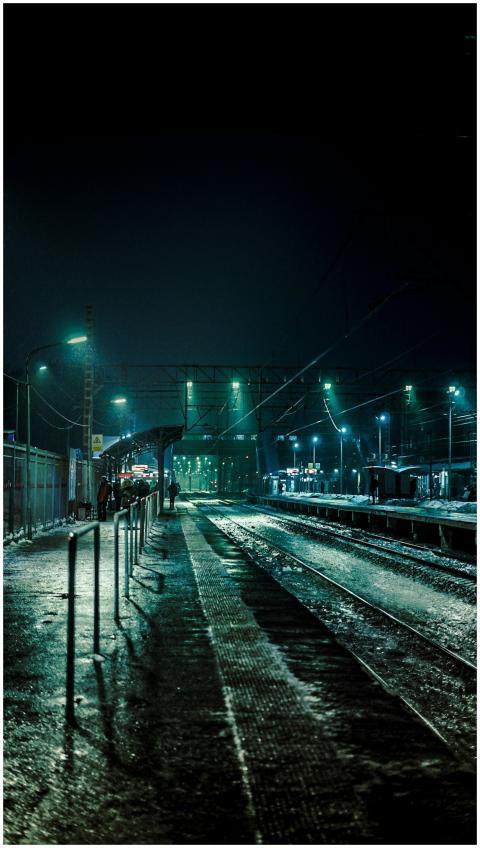 A deserted train station illuminated by streetligh