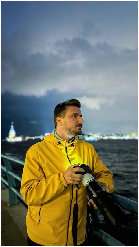 A person with a camera by the waterfront during du