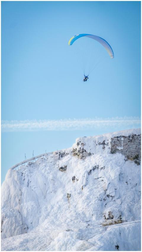 Paragliding high above the scenic snowy terraces o