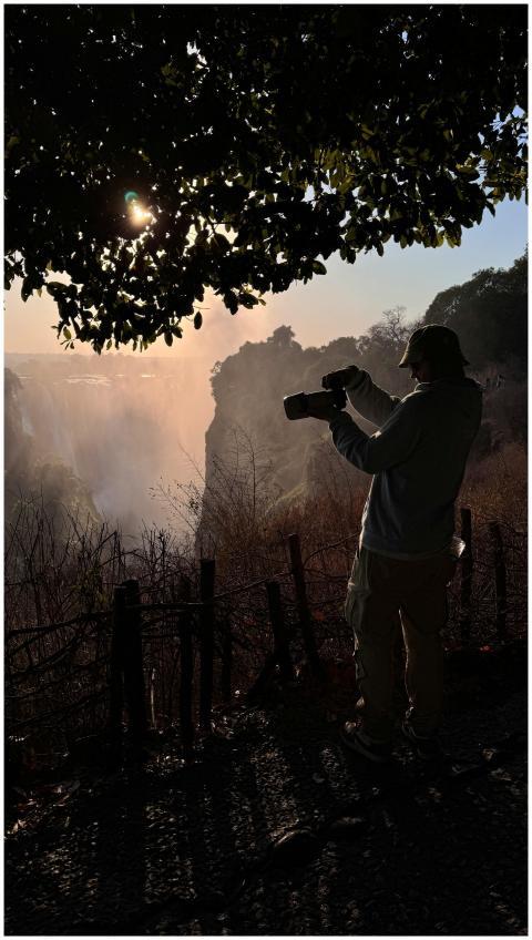 Silhouette of a photographer at sunrise capturing