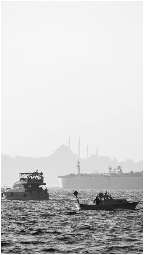 Monochrome view of boats on the sea with a distant