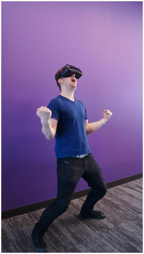 Adult male enjoying virtual reality, expressing ex