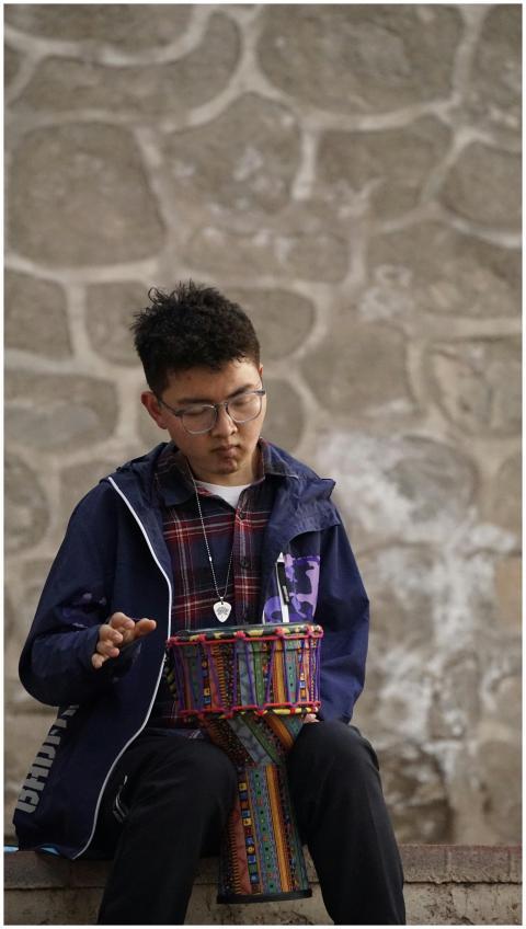 A young man focuses on playing a bright, colorful