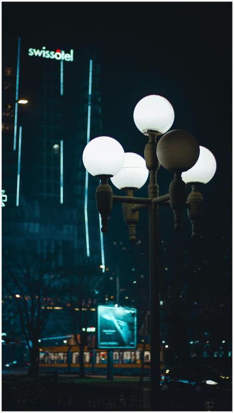 Illuminated street lamp with Swissotel in the back