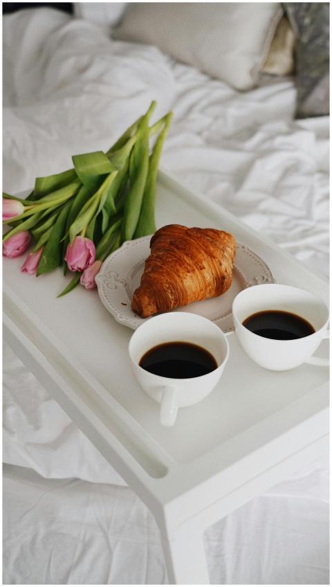 A cozy morning scene with coffee, croissant, and t