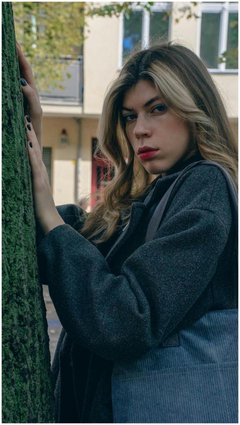 Stylish woman in a grey blazer posing outdoors aga