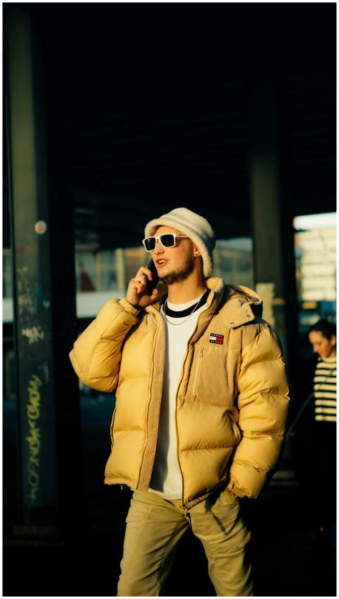 Trendy young man in yellow jacket and sunglasses t