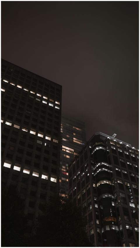 Tall high-rise buildings under a dark, moody sky a