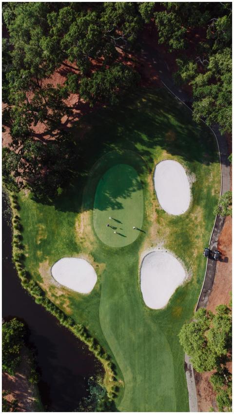 Aerial shot of a green golf course with sand bunke