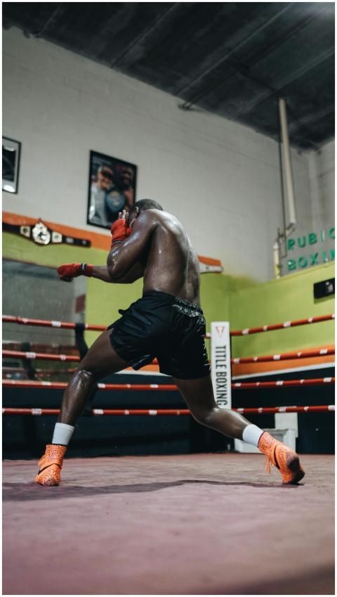 An athlete training hard in a boxing ring inside a