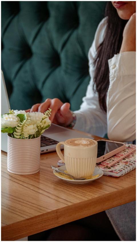 Woman enjoying coffee while working on a laptop in